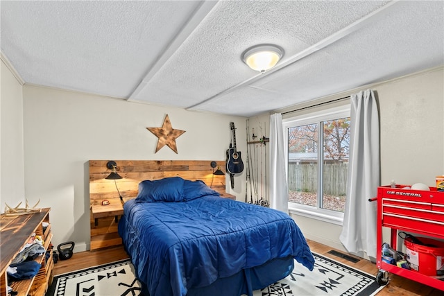 bedroom featuring wood-type flooring and a textured ceiling