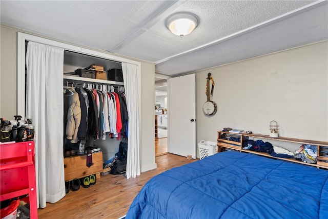 bedroom with a closet, wood-type flooring, and a textured ceiling