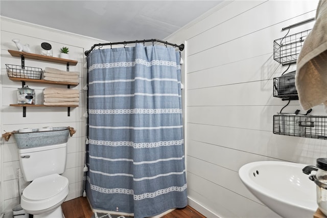 bathroom with a shower with shower curtain, toilet, wood-type flooring, and crown molding