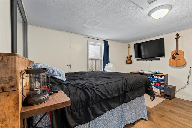 bedroom featuring wood-type flooring and a textured ceiling