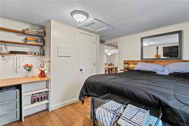 bedroom with a textured ceiling and light hardwood / wood-style floors