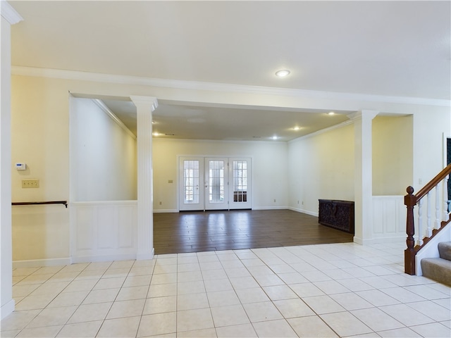 unfurnished living room featuring light tile patterned floors, ornate columns, and ornamental molding