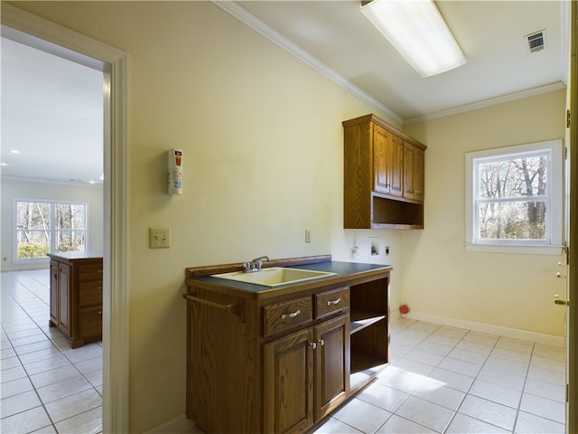 kitchen featuring light tile patterned flooring, ornamental molding, and sink