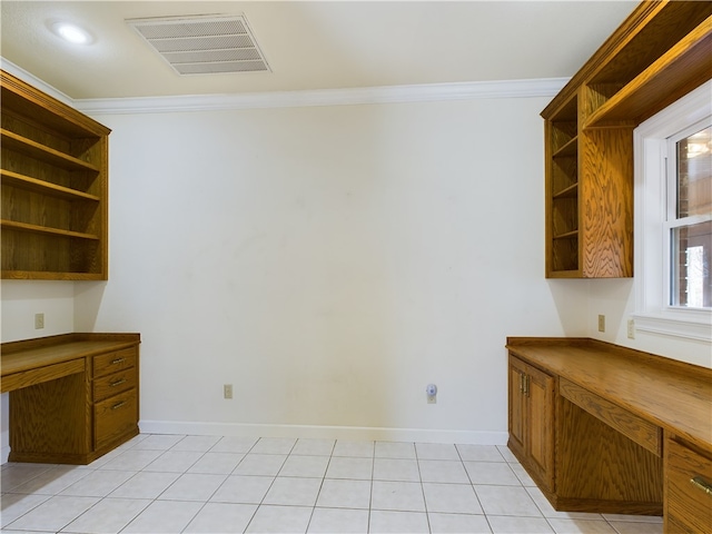 interior space with light tile patterned floors, built in desk, and ornamental molding