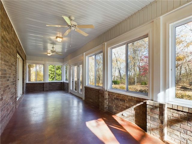 unfurnished sunroom with ceiling fan