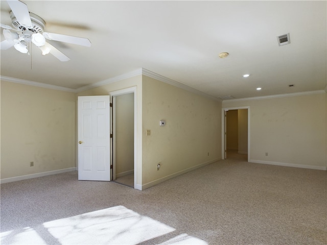 spare room with ceiling fan, light colored carpet, and ornamental molding