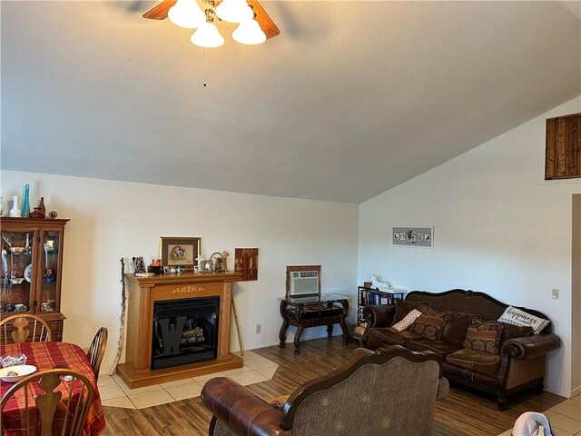 living room with ceiling fan, vaulted ceiling, and light tile patterned floors