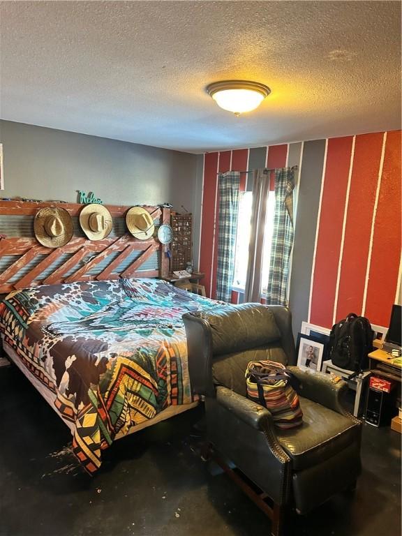 bedroom featuring a textured ceiling and concrete flooring