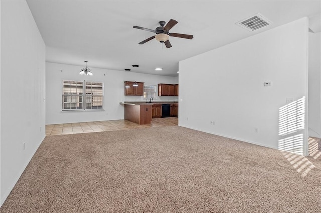 unfurnished living room featuring light colored carpet and ceiling fan with notable chandelier