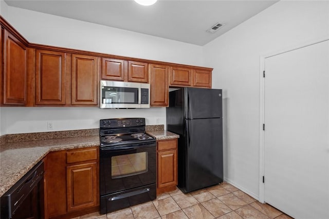 kitchen with light tile patterned floors, stone countertops, and black appliances