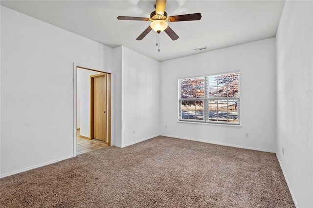 carpeted spare room featuring ceiling fan