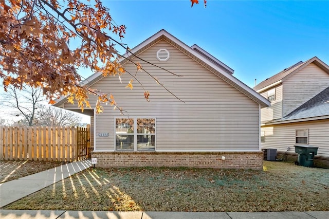 rear view of property with a lawn and cooling unit