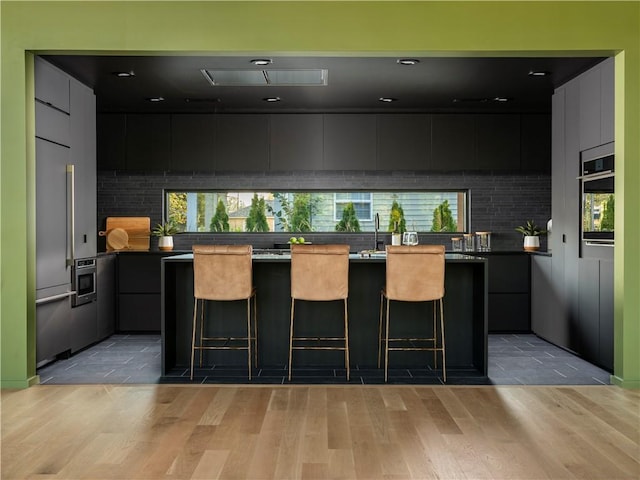 kitchen with a kitchen breakfast bar, oven, and a kitchen island