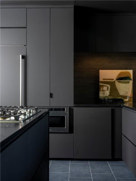 kitchen featuring stainless steel appliances and dark tile patterned floors