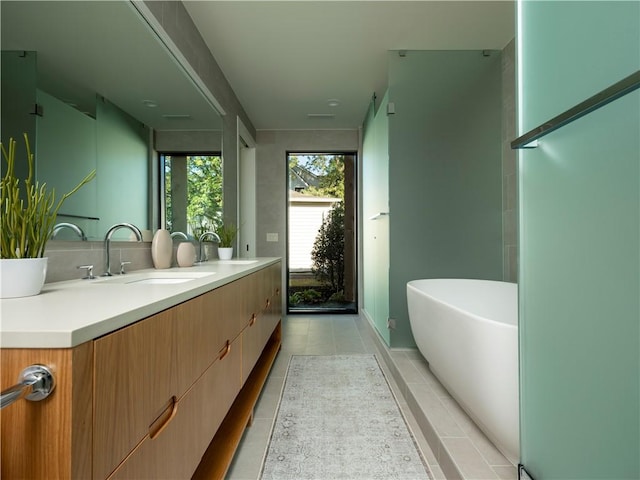 bathroom with vanity, a bathing tub, and tile patterned floors