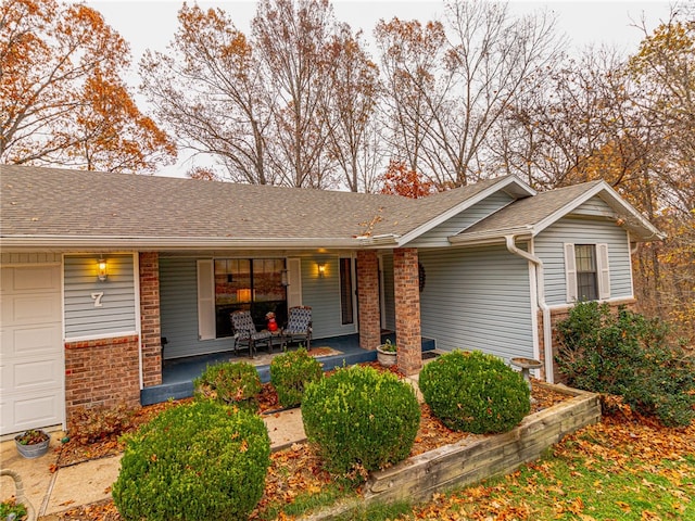 ranch-style house featuring covered porch and a garage