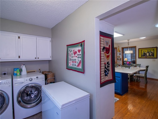 laundry room with cabinets, independent washer and dryer, a textured ceiling, and dark wood-type flooring