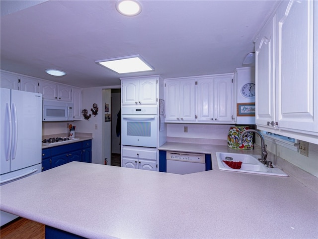 kitchen featuring kitchen peninsula, white cabinets, and white appliances