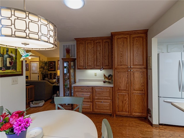 kitchen with dark hardwood / wood-style floors, white fridge, and hanging light fixtures