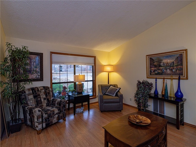 living room with lofted ceiling, hardwood / wood-style floors, and a textured ceiling