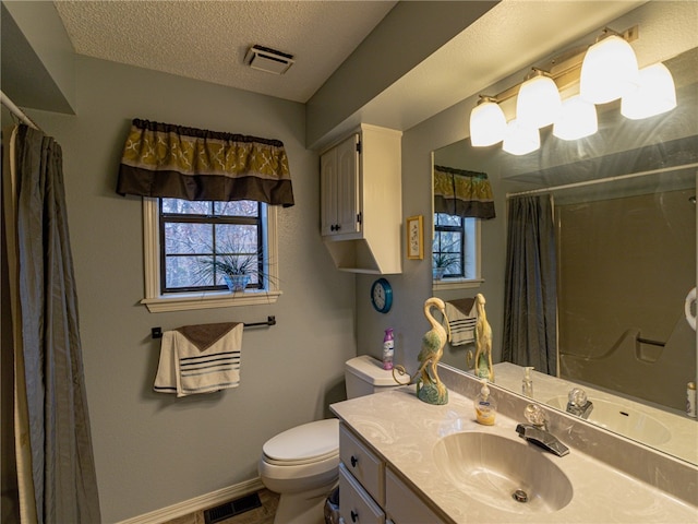 bathroom featuring a textured ceiling, vanity, toilet, and plenty of natural light