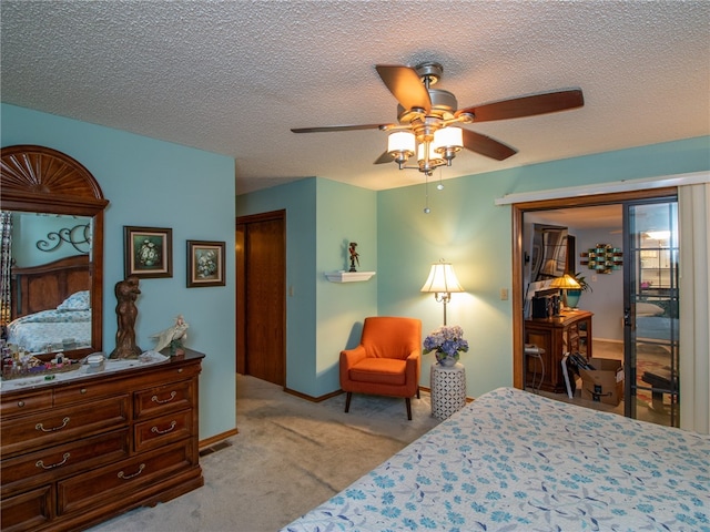 carpeted bedroom featuring ceiling fan and a textured ceiling