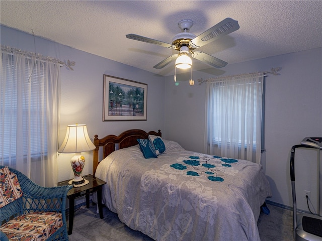 carpeted bedroom with ceiling fan and a textured ceiling