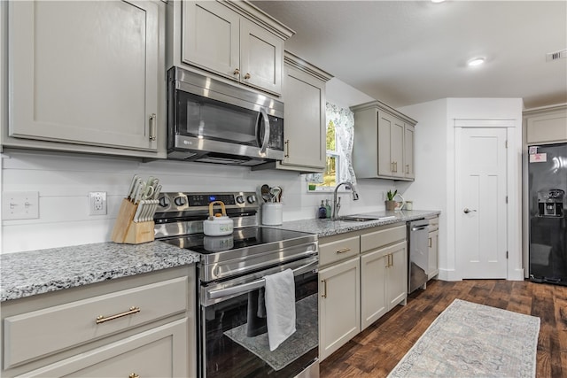 kitchen featuring gray cabinetry, light stone countertops, sink, stainless steel appliances, and dark hardwood / wood-style flooring