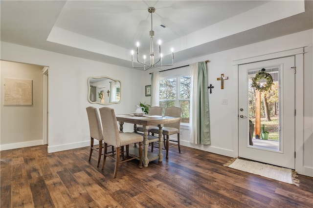 dining room featuring a notable chandelier, dark hardwood / wood-style floors, and a tray ceiling