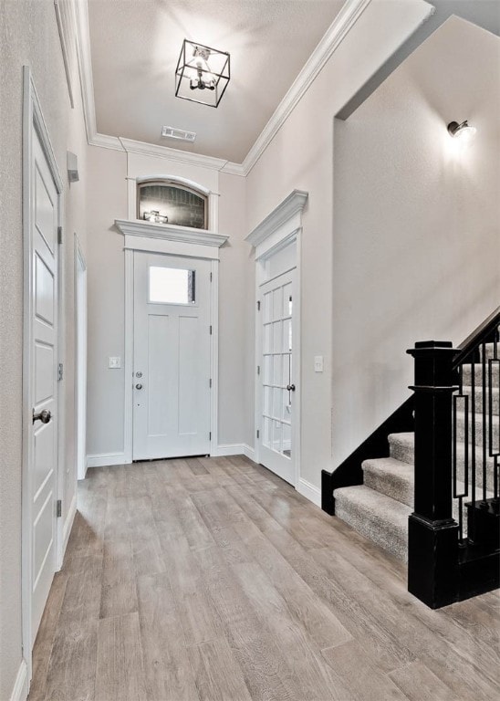 foyer featuring ornamental molding and light hardwood / wood-style flooring