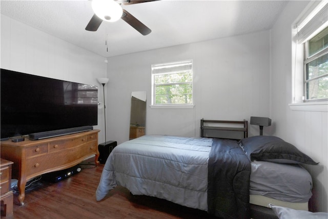 bedroom featuring hardwood / wood-style floors, a textured ceiling, multiple windows, and ceiling fan