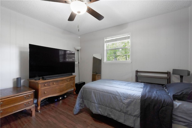 bedroom with ceiling fan, dark hardwood / wood-style flooring, and a textured ceiling