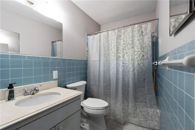 bathroom with vanity, a textured ceiling, and tile walls