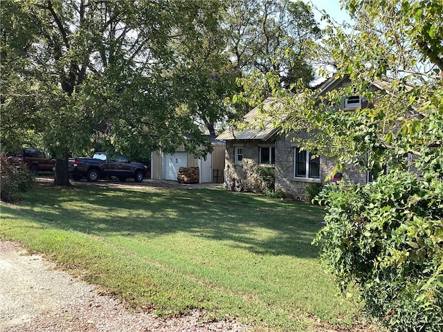 view of property hidden behind natural elements with a garage and a front lawn