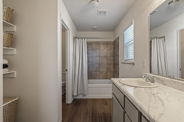 full bathroom featuring vanity, toilet, shower / bathtub combination with curtain, and hardwood / wood-style flooring