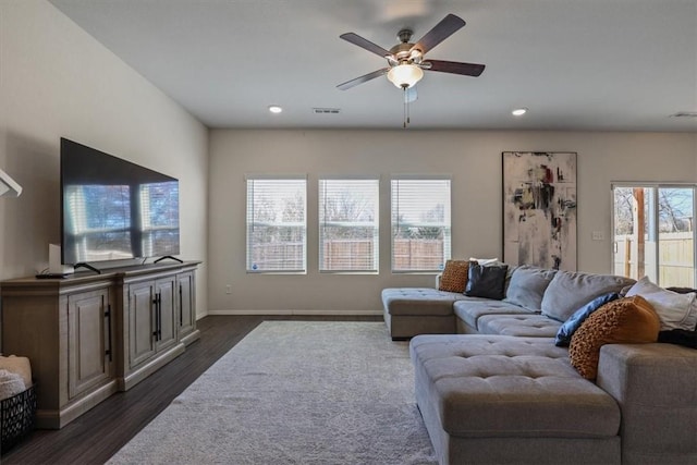 living room with ceiling fan and dark hardwood / wood-style flooring