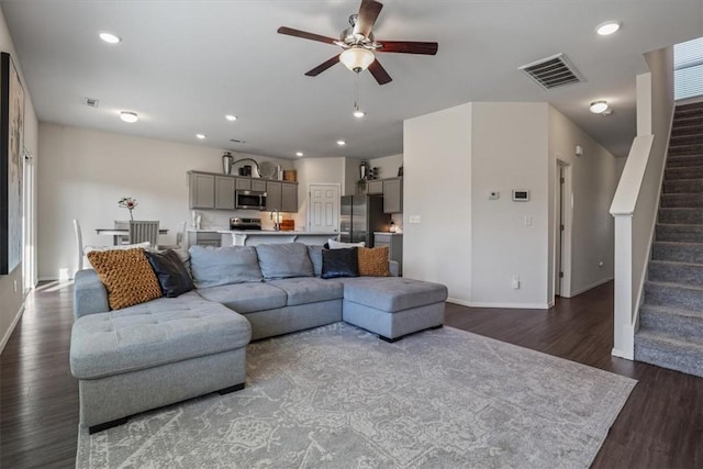 living room with ceiling fan and dark hardwood / wood-style flooring