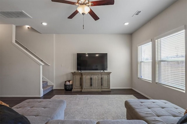 living room with ceiling fan and dark wood-type flooring