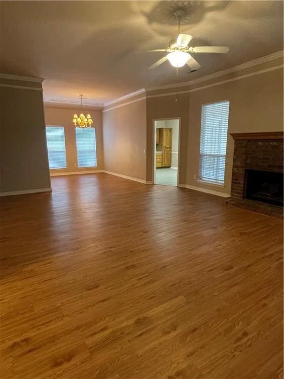 unfurnished living room with dark wood-type flooring, ceiling fan with notable chandelier, and ornamental molding