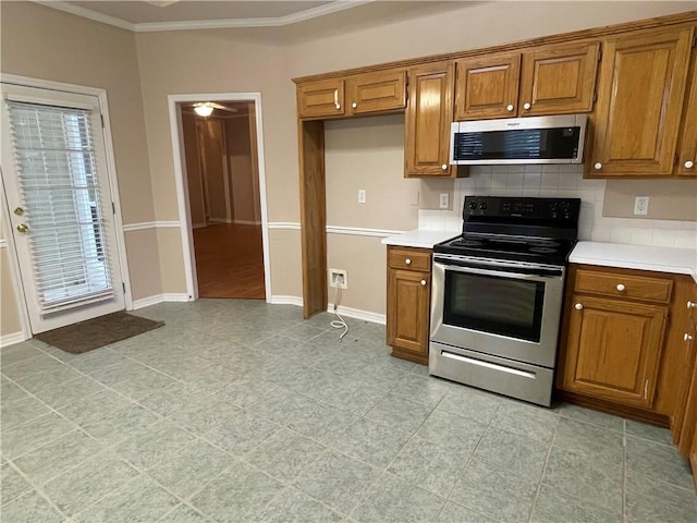 kitchen with tasteful backsplash, stainless steel appliances, and ornamental molding