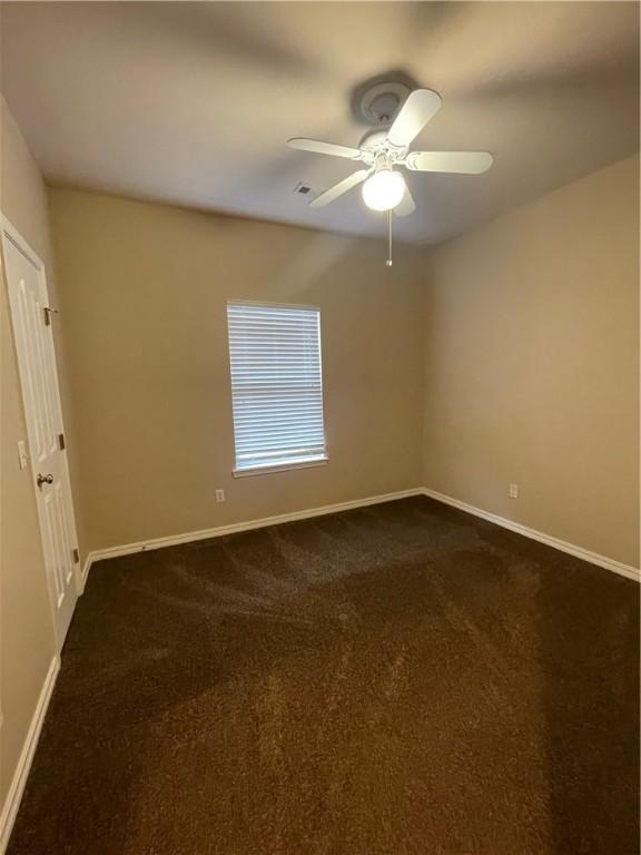 carpeted spare room featuring ceiling fan