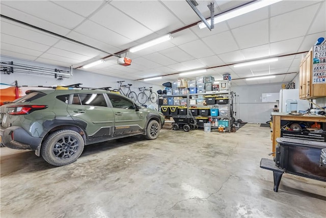 garage with a garage door opener and white refrigerator