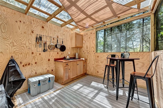 interior space featuring lofted ceiling with skylight and light brown cabinetry