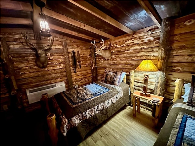 bedroom with beam ceiling, light hardwood / wood-style floors, an AC wall unit, and rustic walls