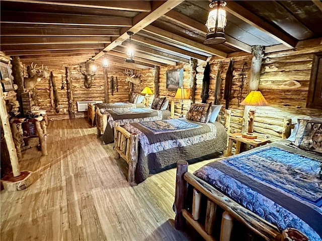 bedroom featuring hardwood / wood-style floors, vaulted ceiling with beams, and rustic walls