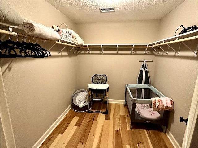 spacious closet with hardwood / wood-style flooring