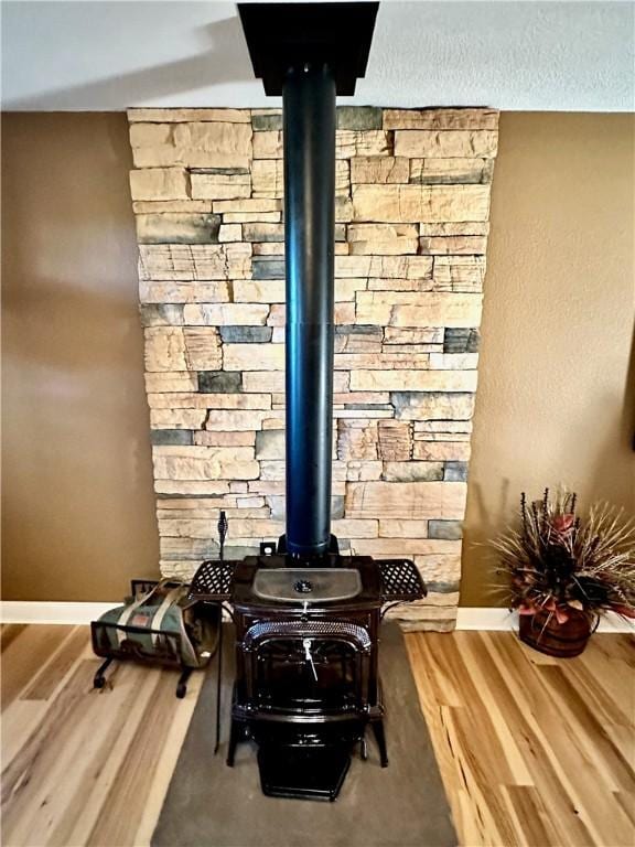 room details with a wood stove and hardwood / wood-style flooring