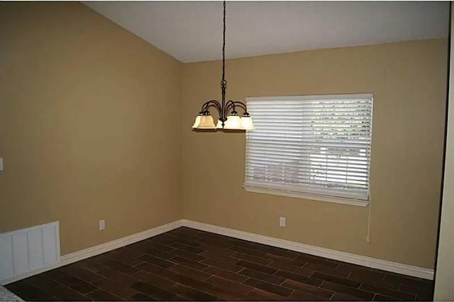 unfurnished dining area featuring vaulted ceiling, dark hardwood / wood-style floors, and a notable chandelier