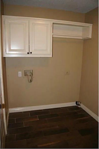 laundry area featuring washer hookup, cabinets, and dark wood-type flooring