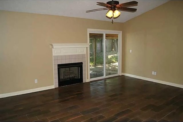 unfurnished living room featuring ceiling fan, dark wood-type flooring, and a tiled fireplace